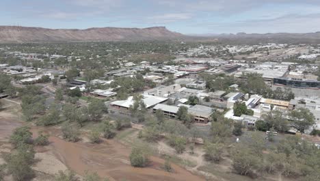 alice springs remote town with muddy water flower at todd river during daytime - heavitree gap in macdonnell ranges, northern territory, australia. - aerial
