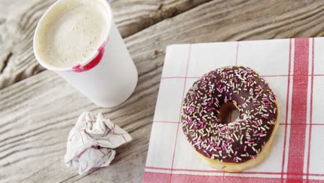 marca de lápiz labial en taza de café y rosquilla de chocolate con salpicaduras