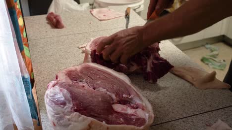 butcher cutting fresh pork meat in slaughterhouse