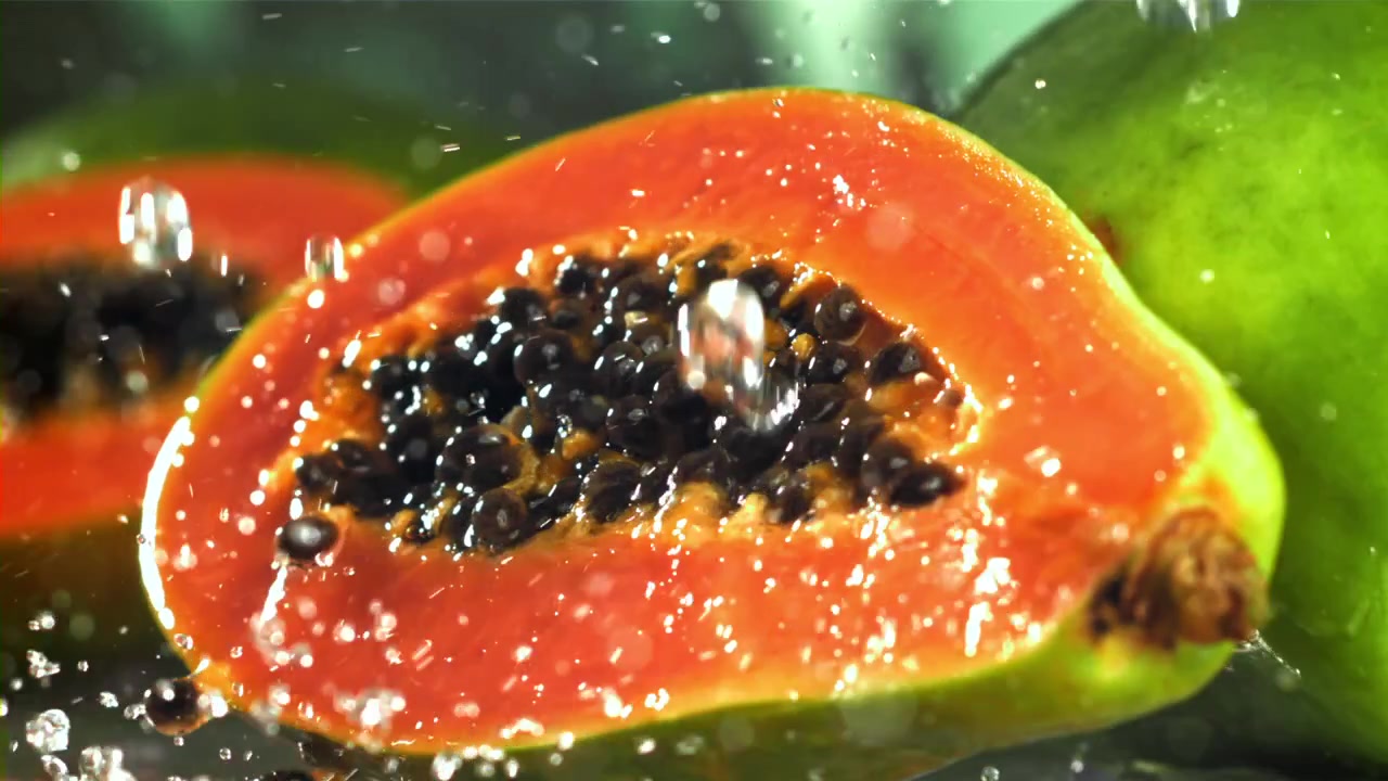 Metà di papaya fresca con schizzi d'acqua al rallentatore