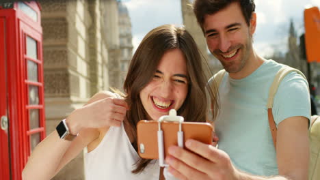 A-cheerful-young-couple-looking-a-smartphone