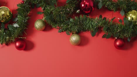 Christmas-decorations-with-baubles-and-copy-space-on-red-background