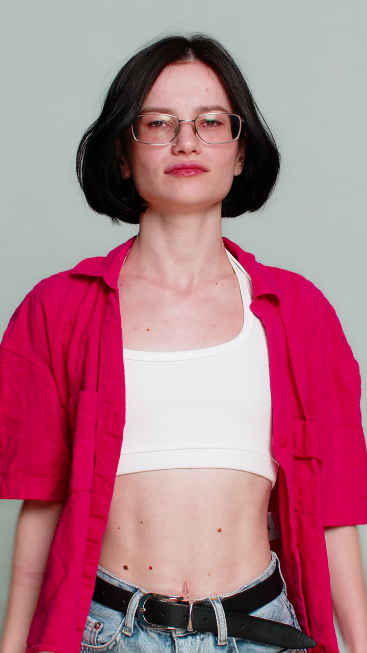 Woman shows thumbs down with serious expression expressing dislike disagreement or disappointment