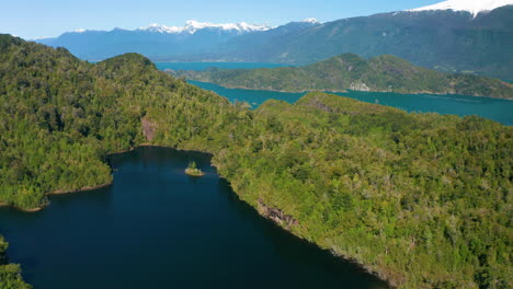 Amplia-Vista-Aérea-Del-Estuario-Del-Reloncavi,-En-La-Costa-De-Chile,-Que-Muestra-Exuberantes-Bosques-Verdes-Y-Montañas-Nevadas