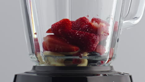 milk pouring blender fruits berries in super slow motion closeup. cook milkshake