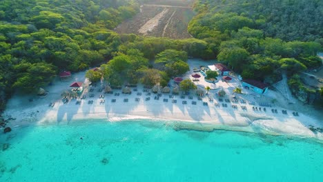 el avión no tripulado desciende para inclinarse y mostrar el cuchillo grande curacao o playa kenapa retroiluminado al amanecer