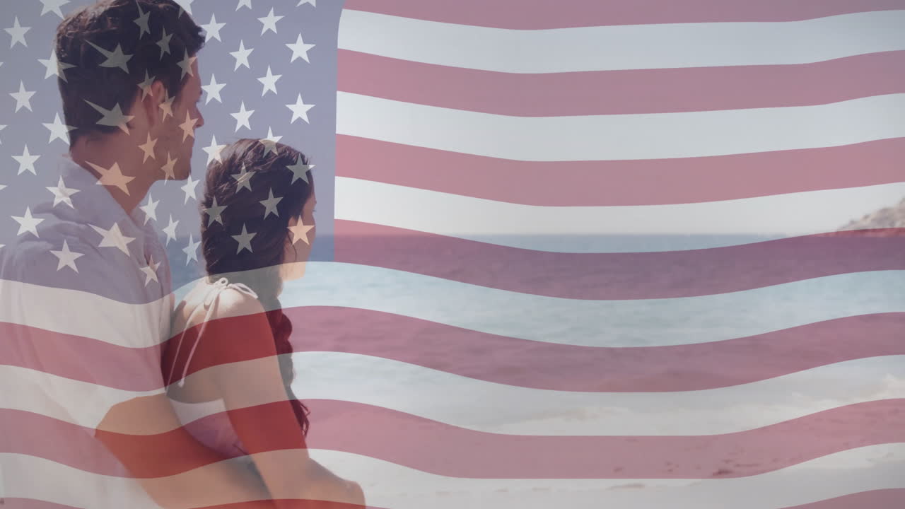 animación de la bandera estadounidense sobre una pareja abrazándose y mirando el océano