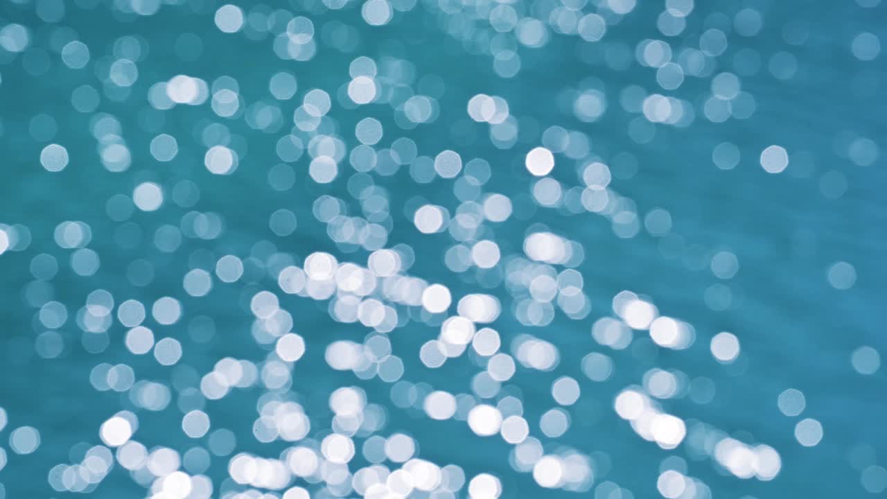 물줄기에 반사되는 태양의 반이는 배경의 초점 밖의 추상적인 흐릿한 이동