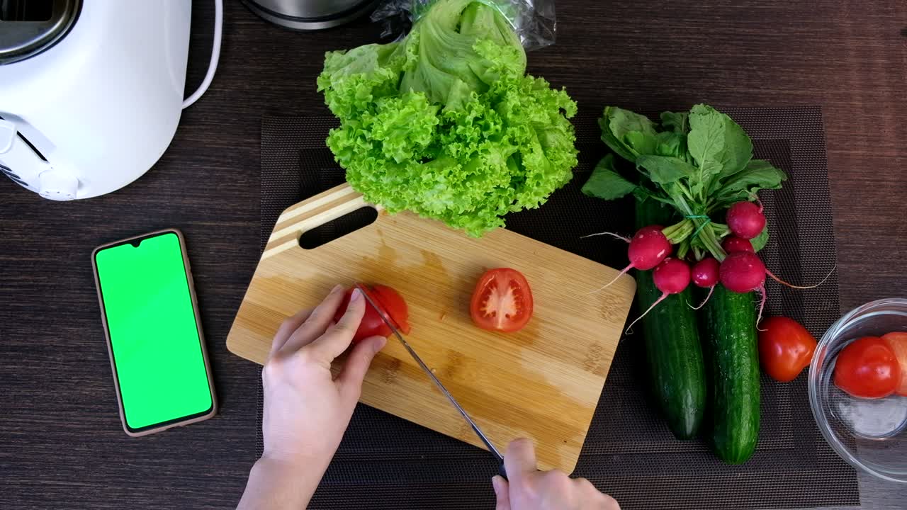 persona vista tomates cortados cocinando ensalada de verduras frescas teléfono con pantalla verde