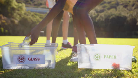recycling at school, girls sorting glass and paper into separate bins