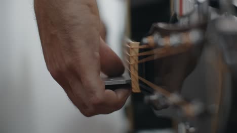 person adjusting guitar neck
