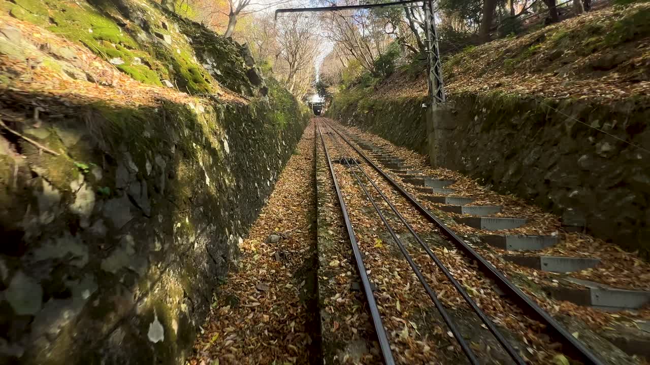 Eizan cable car going down mountain during fall colors in Japan