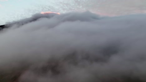 volando a través de nubes y niebla al atardecer