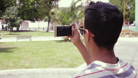 Hombre-En-El-Parque-Usando-Su-Celular-Para-Tomar-Fotos-Y-Videos-De-La-Naturaleza