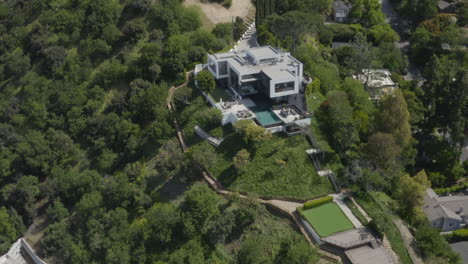 4k aerial of a modern mansion on a hill in studio city california.