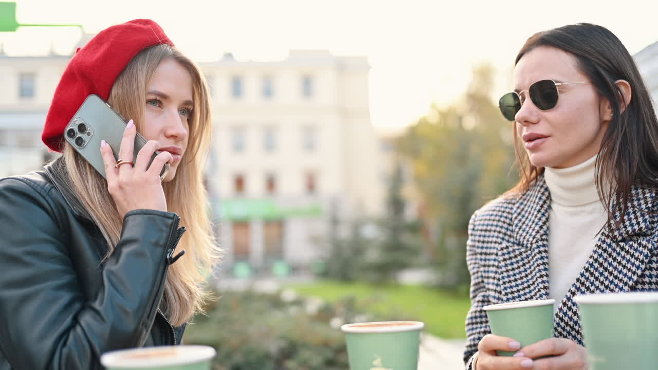 Two women talking and drinking coffee at a terrace