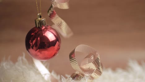 christmas red bauble swinging with white and gold ribbon background