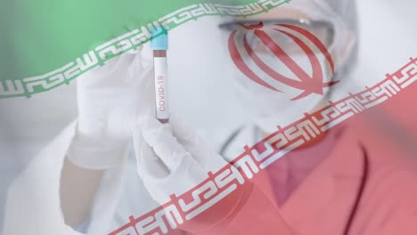 bandera iraní ondeando contra una científica que sostiene un tubo de ensayo con el texto covid-19