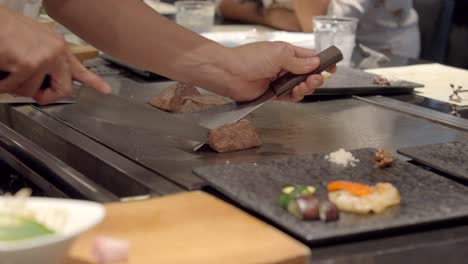 japanese chef cut slice kobe wagyu meat showing marble of authentic certified japan meat over teppanyaki restaurant at osaka