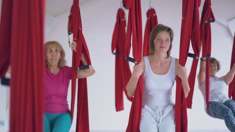 blonde woman in white sport suit relaxes after flying yoga