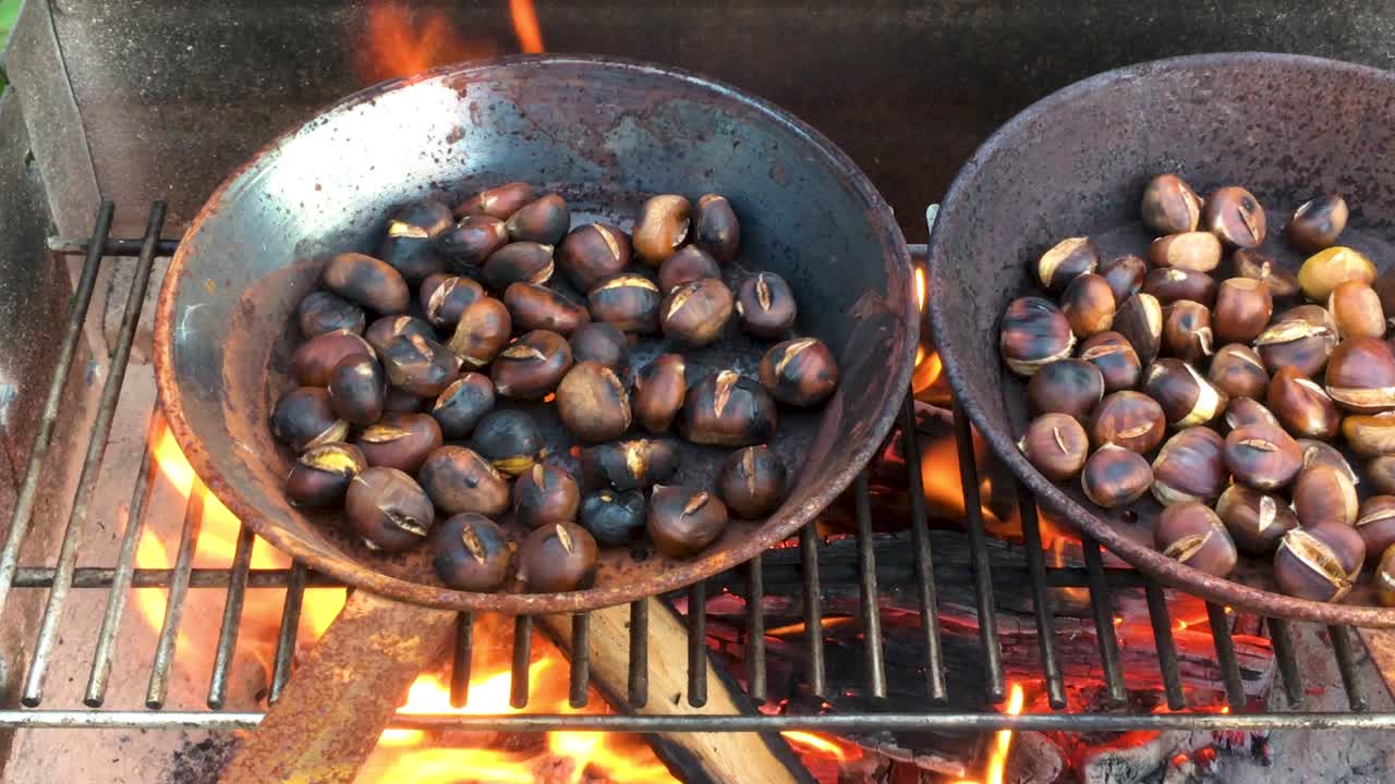 Chestnuts roasted on open fire, seasonal delicacy, harvest, 4k UHD, close up, pan shot