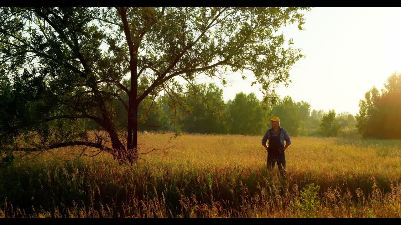 Un contadino in un campo al tramonto