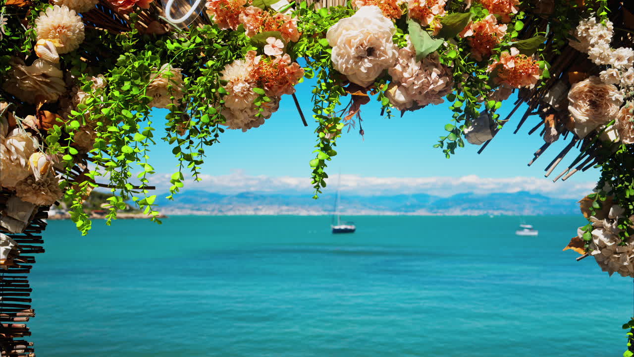 Close up of an orange flower arrangement with the blue sea on the background
