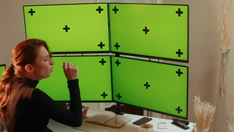 young woman, multiple green screen computer monitors with tracking