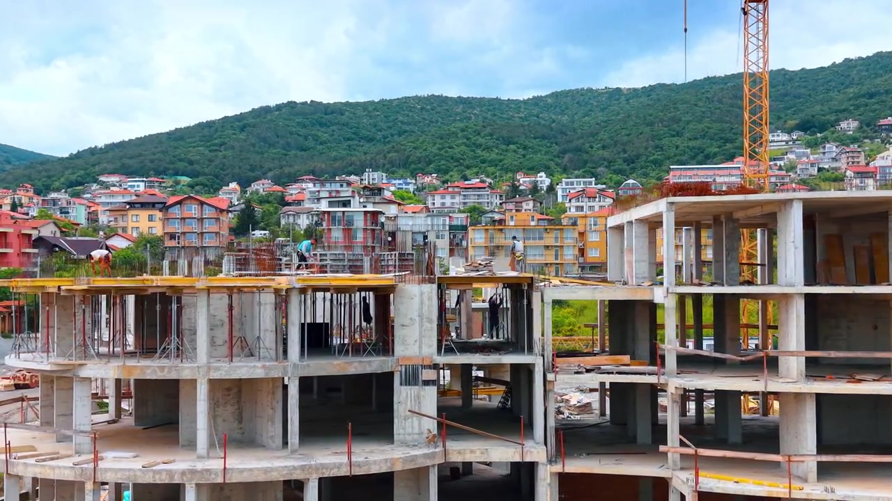 Cấu trúc khung bê tông nguyên khối của tòa nhà dân cư nhiều tầng. Cận cảnh khung xương tòa nhà bê tông cốt thép chưa hoàn thiện với vật liệu ván khuôn nhìn từ phía trước