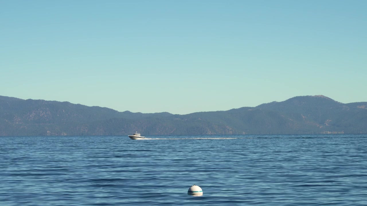 Motoscafo che si muove velocemente su un lago alpino lasciando una scia