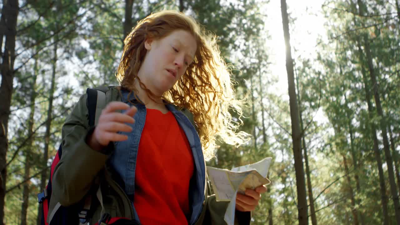 mujer mirando el mapa en el bosque 4k