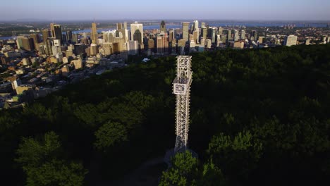 Drone-shot-circling-the-Mount-Royal-Cross,-sunny-evening-in-Montreal-city,-Canada