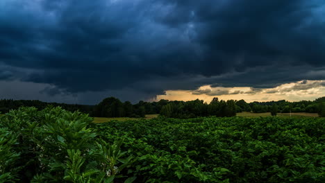 Formation-of-dramatic-grey-sky-with-dense-dark-clouds-covering-farm-fields-in-nature,time-lapse