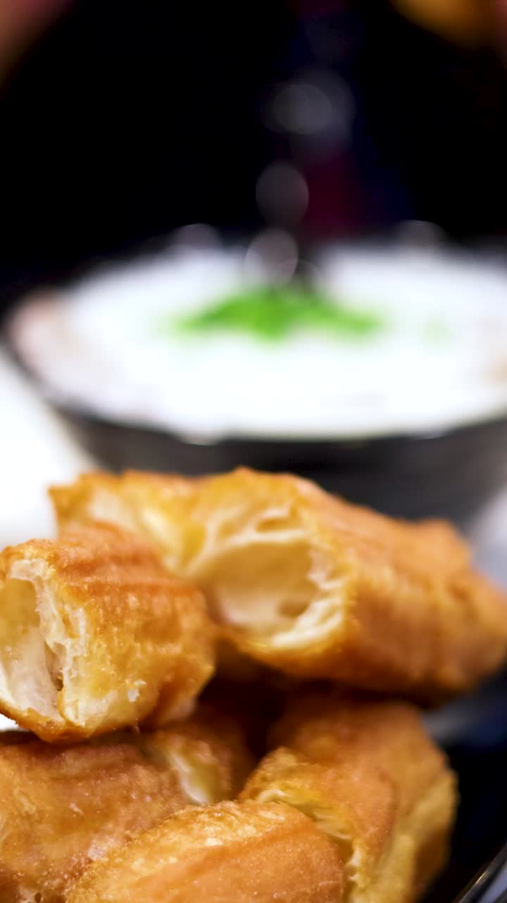 Hands preparing deep-fried dough sticks