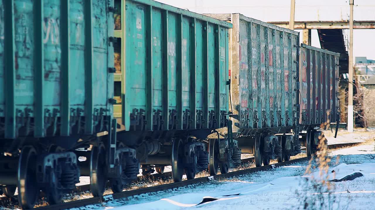 오래된 화물 열차가 눈 덮인 철도를 따라 움직이고 있어요