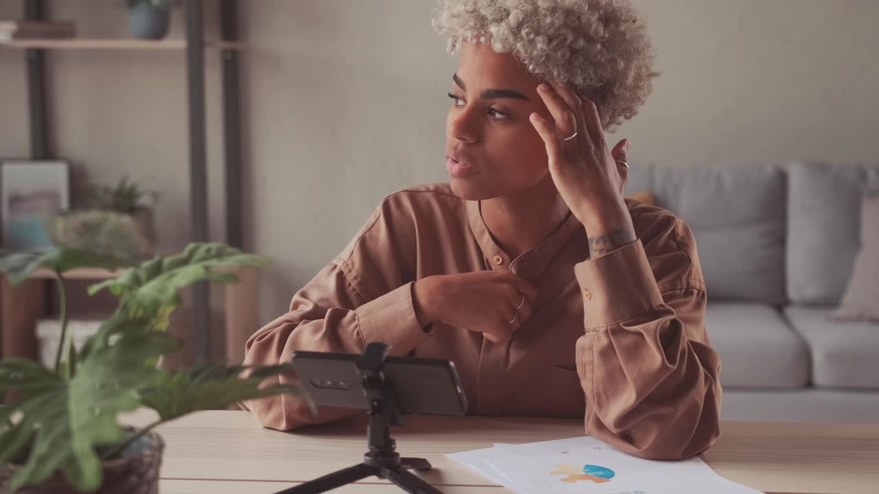 African woman blogger or vlogger looking at camera and talking on video shooting