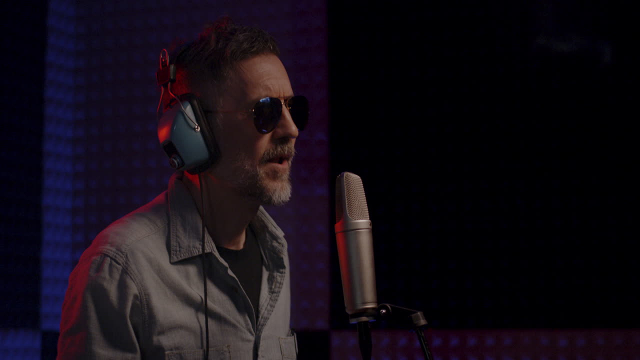 hombre cantando en un micrófono en un estudio de grabación