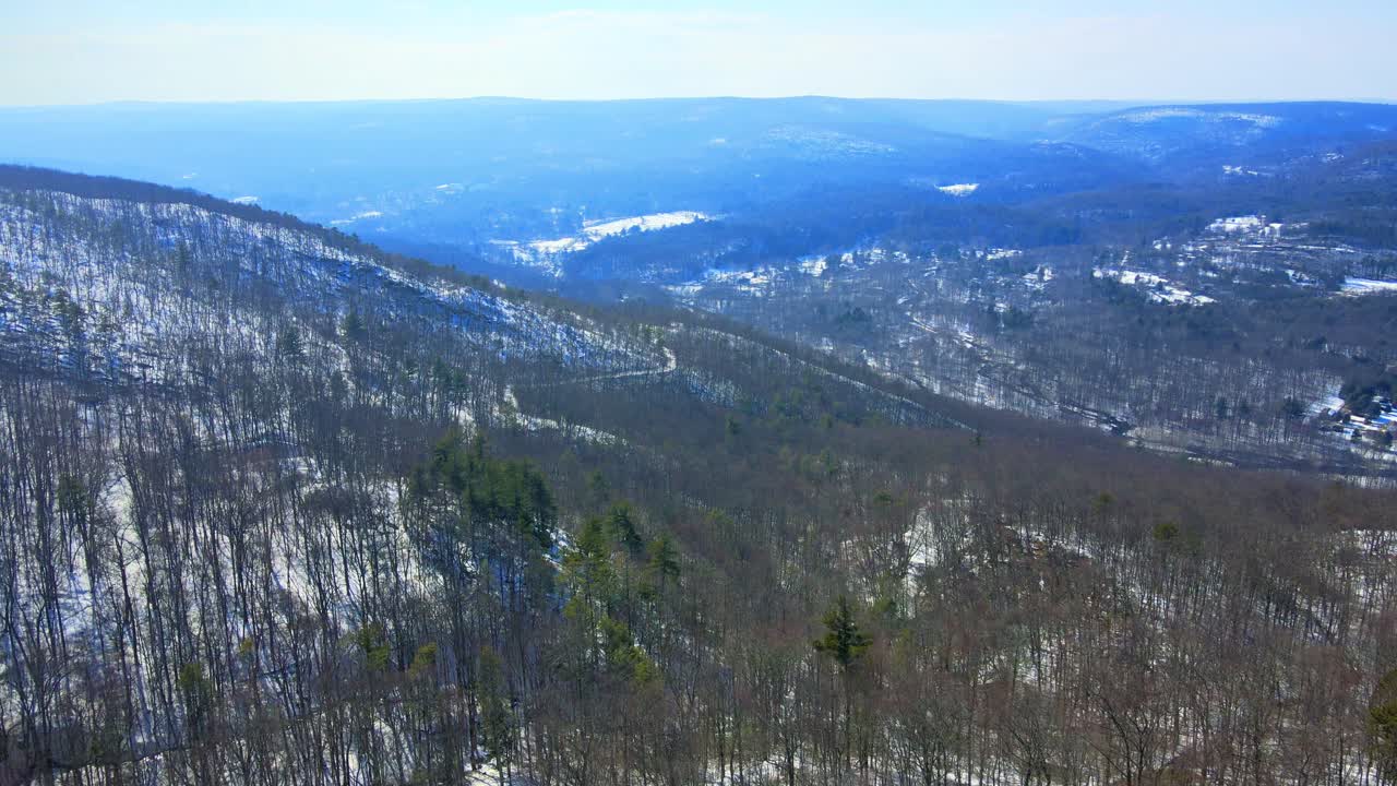 imágenes de video de drones aéreos de un valle de montaña cubierto de nieve a principios de la primavera con cielos azules soleados