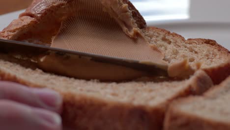 la mantequilla de maní se pone en el pan.