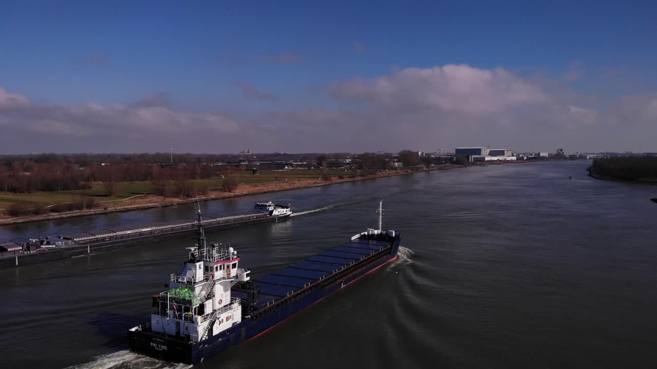 Empty Cargo Ships Sailing Across The River Of Oude Maas In South Holland, Netherlands On A Sunny Day. drone orbit