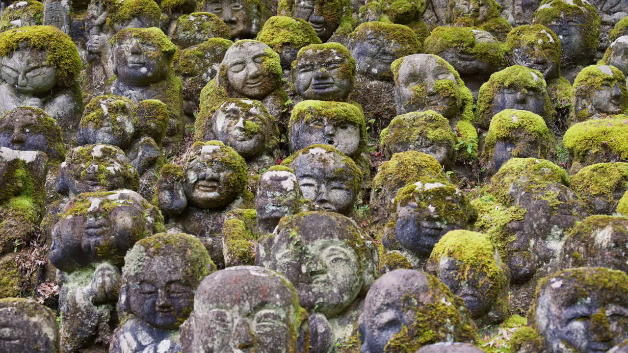 Moss-covered arhat statues covering the hillside around the temple grounds at the Otagi Nenbutsuji Temple in Kyoto, Japan