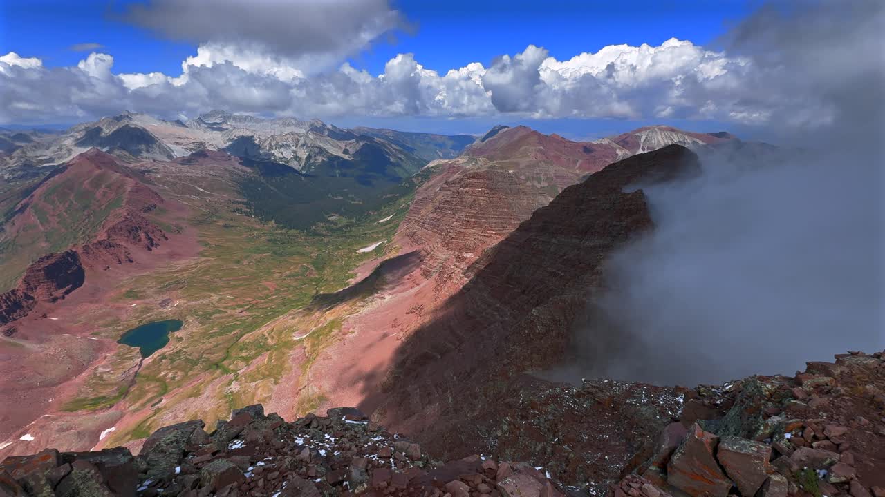 North Maroon Peak Aspen Snowmmass Maroon Bells Wilderness foggy sunny top of fourteener panoramic view Capitol Peak Mount Snowmass Colorado summer Elk Range Rocky Mountains rugged terrain pan left
