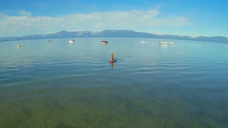 Una-Toma-Aérea-De-Una-Mujer-Y-Su-Perro-Remando-En-El-Lago-Tahoe-3