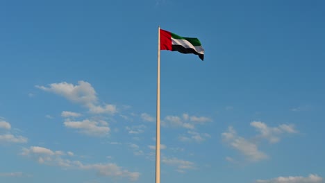 bandeira dos emirados árabes unidos acenando no ar nublado céu azul no fundo, ilha de bandeira de sharjah, dia nacional dos emirados árabes unidos, filmagem de inverno, vídeo 4k