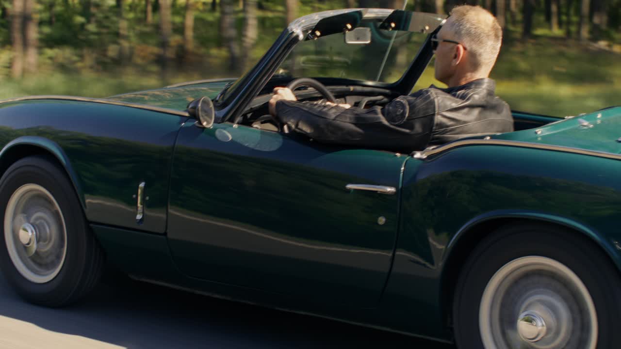 Man Driving a Green Convertible Car