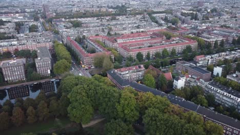 aerial view approaching amsterdam, the netherlands, you can see the canals and the architecture of its typical houses and a very leafy park