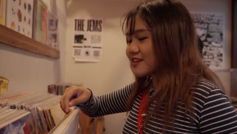 happy girl with a joyful grin, browsing through records, where to begin