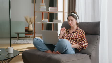 caucasian lady wearing wireless headphones get online instruction using laptop