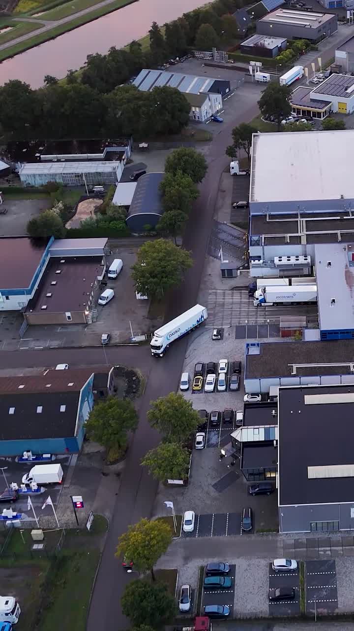 Aerial view of an industrial area with trucks, cars, and buildings