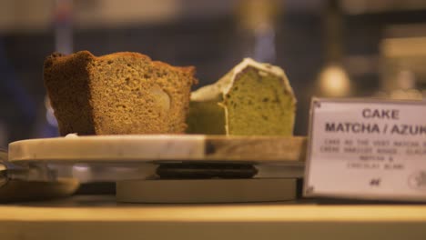 french cake in a bakery in france being served to a client with a wooden kitchen tongs